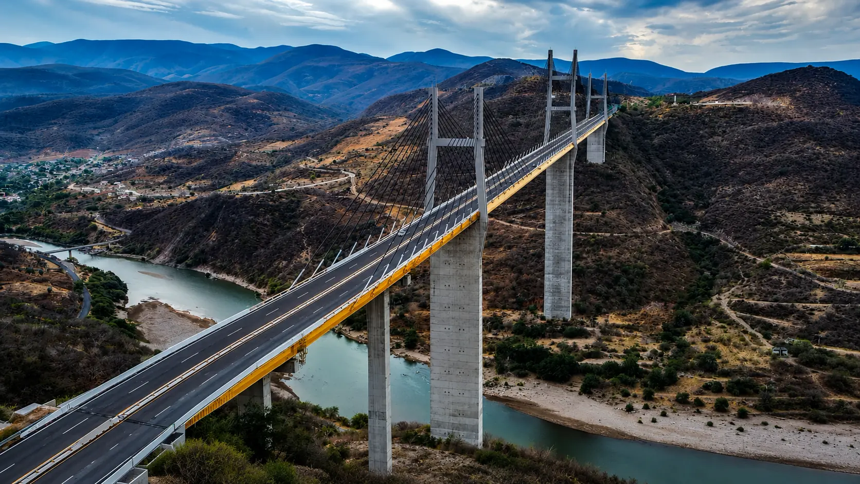 Puente atirantado sobre un río, entre montañas